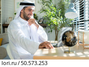 Portrait of young Arabic businessman working on laptop at home. Стоковое фото, агентство Ingram Publishing / Фотобанк Лори