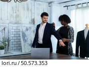 In a modern clothes fashion room, a clothing designer or tailor allows buyers to try on molded outfits before sewing them. Стоковое фото, агентство Ingram Publishing / Фотобанк Лори