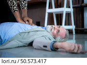 An elderly businessman suffered a sudden heart failure at work, A coworker was administering CPR to offer basic life support. Стоковое фото, агентство Ingram Publishing / Фотобанк Лори
