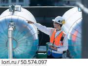 Engineers inspect the completed air conditioning and water systems to continue verifying their functionality. Стоковое фото, агентство Ingram Publishing / Фотобанк Лори