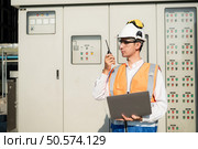 Before proceeding with the testing, Electrical engineer inspects the installed control panel. Стоковое фото, агентство Ingram Publishing / Фотобанк Лори