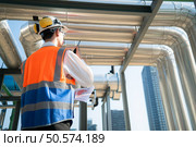 Back view of Engineers inspect the completed air conditioning and water systems to continue verifying their functionality. Стоковое фото, агентство Ingram Publishing / Фотобанк Лори