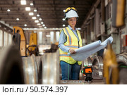 Portrait of railway technician worker in safety vest and helmet working with blueprint at train repair station. Стоковое фото, агентство Ingram Publishing / Фотобанк Лори