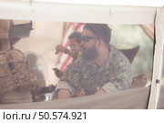 Group of soldiers in camouflage uniforms hold weapons in a field tent, Plan and prepare for combat training. Стоковое фото, агентство Ingram Publishing / Фотобанк Лори