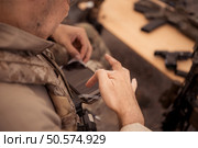 Group of soldiers in camouflage uniforms hold weapons in a field tent, Plan and prepare for combat training. Стоковое фото, агентство Ingram Publishing / Фотобанк Лори