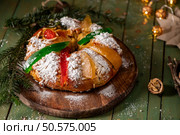 A festive King Cake adorned with colorful candied fruits, dusted with powdered sugar, and ready to be shared. Стоковое фото, агентство Ingram Publishing / Фотобанк Лори