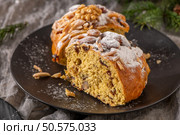 A generous slice of Bolo Rainha, a traditional Portuguese Christmas cake, is displayed on a dark plate. Its rich interior, studded with nuts and fruit, is dusted with powdered sugar. Стоковое фото, агентство Ingram Publishing / Фотобанк Лори