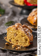 A tempting slice of Bolo Rainha, a traditional Portuguese Christmas cake, is presented on a black plate. It’s topped with almonds and dusted with powdered sugar. Стоковое фото, агентство Ingram Publishing / Фотобанк Лори