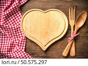 Heart shaped cutting board with a red checkered tablecloth on wooden table. Стоковое фото, агентство Ingram Publishing / Фотобанк Лори