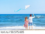 Boy and girl at the beach with a kite. Freedom concept. Carefree childhood and hope. Brother and sister together. Стоковое фото, агентство Ingram Publishing / Фотобанк Лори