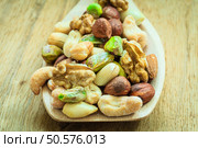 Healthy organic nutrition high fatty acids food and cuisine. Closeup varieties assortment mix of nuts on wooden spoon. Стоковое фото, агентство Ingram Publishing / Фотобанк Лори