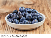 Huckleberries super food in a white china dish on a brown wooden table. Стоковое фото, агентство Ingram Publishing / Фотобанк Лори