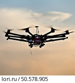 Drone on a background of a beautiful sunset. UAV in flight. Quadrocopters on radio.. Oktokopter, copter, drone. Стоковое фото, агентство Ingram Publishing / Фотобанк Лори