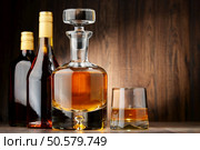 Composition with bottles of assorted alcoholic beverages and glass of whisky. Стоковое фото, агентство Ingram Publishing / Фотобанк Лори