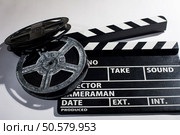 Clap movie on a light background. Metal or plastic film coil. Objects for shooting movies and demonstrations. Clap movie on a light background. Стоковое фото, агентство Ingram Publishing / Фотобанк Лори