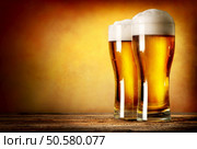 Two glasses of lager on a wooden table. Two glasses of lager. Стоковое фото, агентство Ingram Publishing / Фотобанк Лори