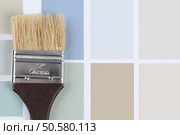 Overhead shot of  a paint brush with a brown handle laying on a sheet of color samples. Horizontal format with copy space. Стоковое фото, агентство Ingram Publishing / Фотобанк Лори