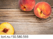 fresh peach fruits on weathered grained cedar wood with a copy space. Стоковое фото, агентство Ingram Publishing / Фотобанк Лори