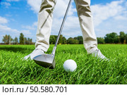 Teeing off. Close-up of male golfer teeing off while standing on golf course. Стоковое фото, агентство Ingram Publishing / Фотобанк Лори