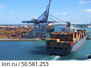 Port of Freeport Bahamas Container shipyard with heavy lifting Cranes and a ship coming in to dock assisted by tug boats. Стоковое фото, агентство Ingram Publishing / Фотобанк Лори