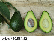 Fresh avocado with avocado leaves on teak wood table top. Стоковое фото, агентство Ingram Publishing / Фотобанк Лори