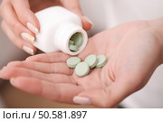 Woman holding pill in hand. Стоковое фото, агентство Ingram Publishing / Фотобанк Лори