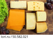 Hard cheeses served on a wooden board. Стоковое фото, агентство Ingram Publishing / Фотобанк Лори
