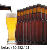 Closeup of a group of beer bottles with a glass being poured. The bottles are arranged with the glass to the side and the pouring bottle partially out of frame. Isolated on a white background with reflection. Стоковое фото, агентство Ingram Publishing / Фотобанк Лори