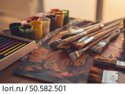 Angle view photo of palette with mixed oil paints, gouache, crayons and paintbrushes set in art studio. Angle view photo of palette with mixed oil paints, gouache, crayons and paintbrushes set in art studio. Стоковое фото, агентство Ingram Publishing / Фотобанк Лори