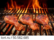BBQ Chicken Legs Roasted On The Hot Flaming Charcoal Grill, Top View Close Up. Стоковое фото, агентство Ingram Publishing / Фотобанк Лори