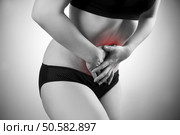 Woman with abdominal pain. Pain in the  human body. Black and white photo with red dot. Woman with abdominal pain. Pain in the human body. Стоковое фото, агентство Ingram Publishing / Фотобанк Лори