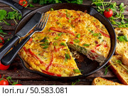 Frittata made of eggs, potato, bacon, paprika, parsley, green peas, onion, cheese in iron pan on wooden table. Frittata made of eggs, potato, bacon, paprika, parsley, green peas, onion, cheese in iron pan. on wooden table. Стоковое фото, агентство Ingram Publishing / Фотобанк Лори