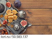 Cup of coffee with baklava and metal oriental tray on wooden background. Стоковое фото, агентство Ingram Publishing / Фотобанк Лори