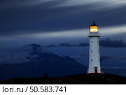 Cape Egmont Lighthouse and Taranaki Mount on background, New Zealand. Стоковое фото, агентство Ingram Publishing / Фотобанк Лори