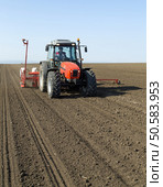 Farmer in tractor sowing corn maize crops. Стоковое фото, агентство Ingram Publishing / Фотобанк Лори
