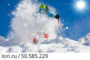 Freeride skier with rucksack running downhill in freeze motion of snow powder.. Freeride skier on piste running downhill. Стоковое фото, агентство Ingram Publishing / Фотобанк Лори