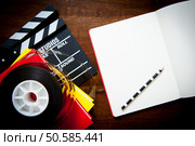 Screenwriter desktop detail with clapper, film reel notebook and pencil. Стоковое фото, агентство Ingram Publishing / Фотобанк Лори