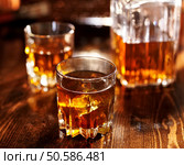 whiskey in glass with decanter in background. Стоковое фото, агентство Ingram Publishing / Фотобанк Лори
