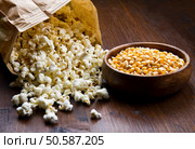 A bowl of popcorn and kernels on a wooden table. Стоковое фото, агентство Ingram Publishing / Фотобанк Лори