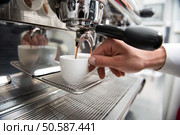 Hands of professional barista holding two white cups on the grating of coffee machine looking how coffee pouring into them. Стоковое фото, агентство Ingram Publishing / Фотобанк Лори