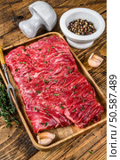 Raw beef round cut meat on a wooden tray with herbs. wooden background. Top view. Стоковое фото, агентство Ingram Publishing / Фотобанк Лори