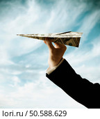 Businessman’s hand holding airplane made of US Dollars. 24316760. Стоковое фото, агентство Ingram Publishing / Фотобанк Лори