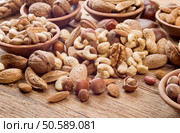 Nuts mix, with almond, cashews, pistachios, hazelnuts on wood background. Стоковое фото, агентство Ingram Publishing / Фотобанк Лори