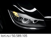 Headlight lamp of black modern car, close-up. Стоковое фото, агентство Ingram Publishing / Фотобанк Лори