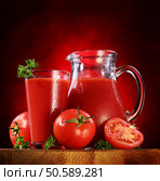 Still life: tomatoes, jug and glass full of fresh tomatoes juice on wooden table. Стоковое фото, агентство Ingram Publishing / Фотобанк Лори