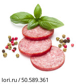 Salami smoked sausage three slices, basil leaves and peppercorns isolated on white background cutout. Стоковое фото, агентство Ingram Publishing / Фотобанк Лори