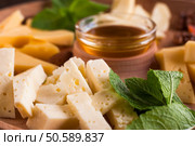 Cheese pieces with honey closeup. Tasty gourmet snack for wine, luxury lifestyle, regale food. Cheese pieces with honey closeup. Стоковое фото, агентство Ingram Publishing / Фотобанк Лори
