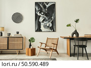 Stylish scandinavian living room interior of modern apartment with wooden commode, design table, chairs, carpet, abstract paintings on the wall and personal accessories in unique home decor. Template. Стоковое фото, агентство Ingram Publishing / Фотобанк Лори