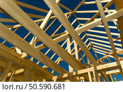 New home under construction with wood, trusses and supplies against blue sky. Стоковое фото, агентство Ingram Publishing / Фотобанк Лори