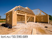 A new home being built with wood, trusses, supports and a foundation. Стоковое фото, агентство Ingram Publishing / Фотобанк Лори